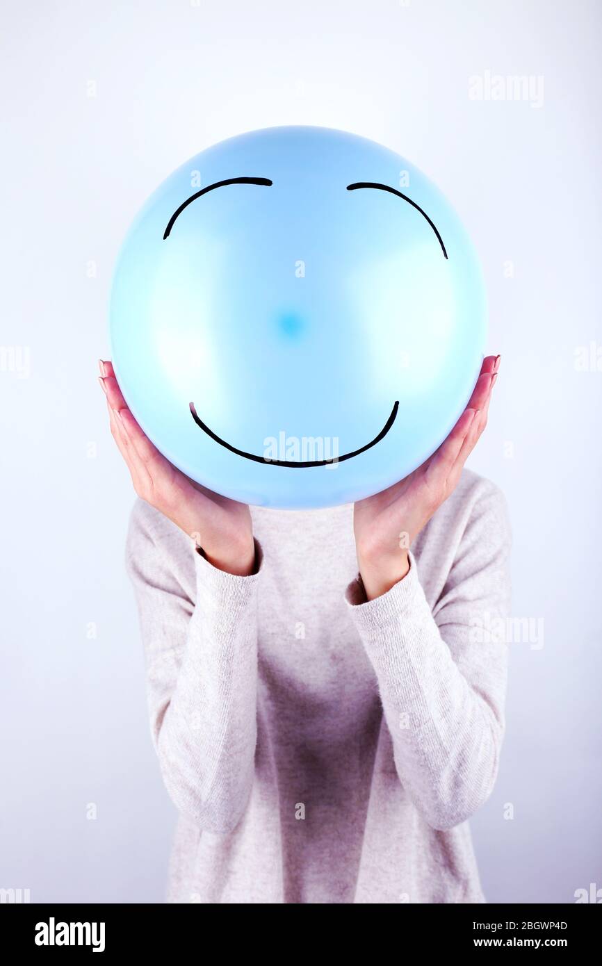 Woman holding balloon in front of her face Stock Photo - Alamy