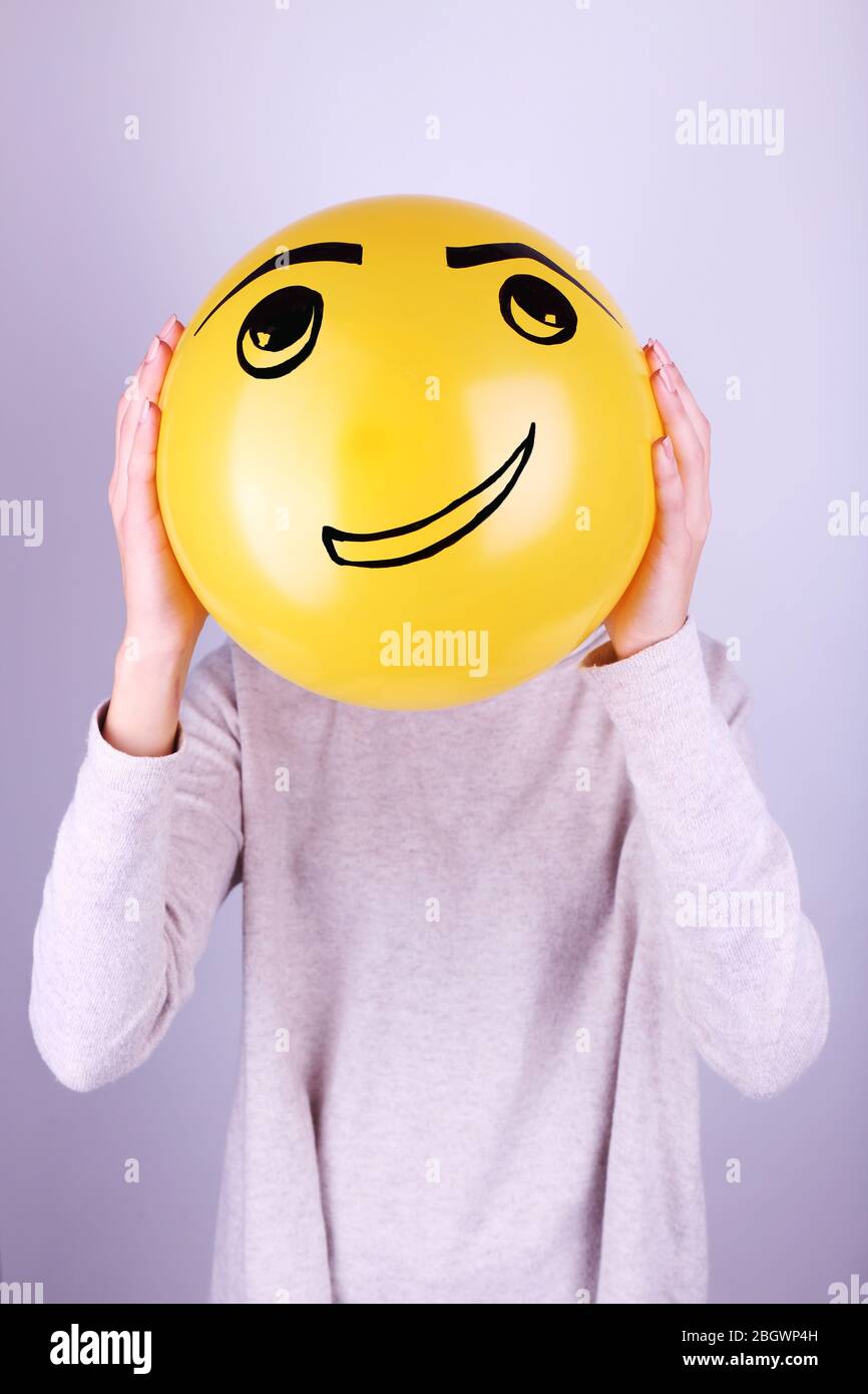Woman holding balloon in front of her face Stock Photo - Alamy