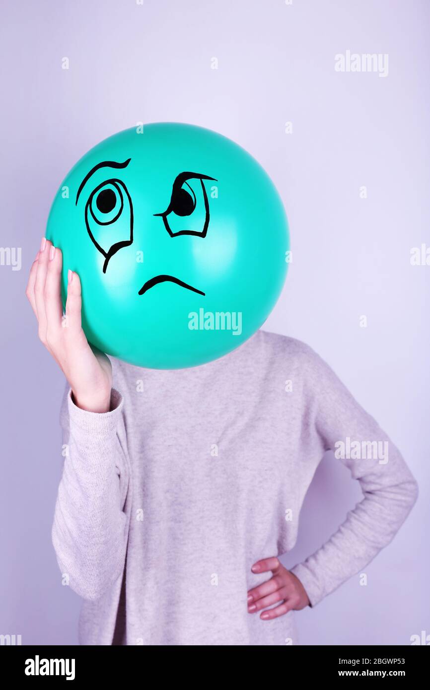 Woman holding balloon in front of her face Stock Photo - Alamy
