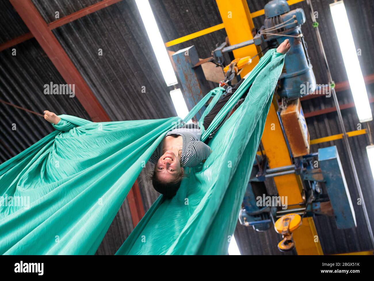 Isaming, Germany. 07th Apr, 2020. Ella Hummel, student at the Academy for  Circus and Performance Art, trains in a Lagehalle with a vertical cloth.  Since her university and all sports halls are