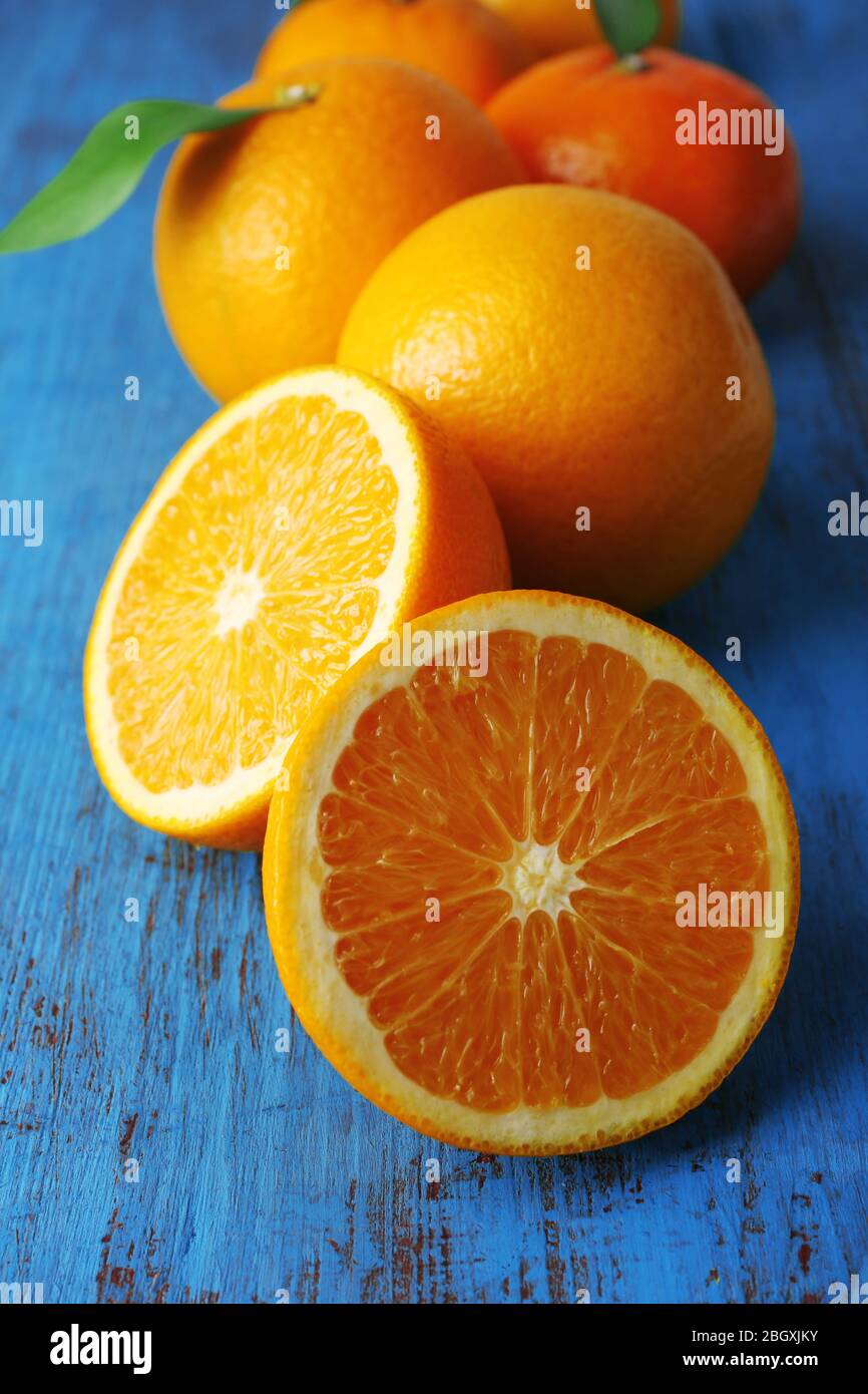 Ripe tangerines and oranges with leaves on wooden background Stock Photo