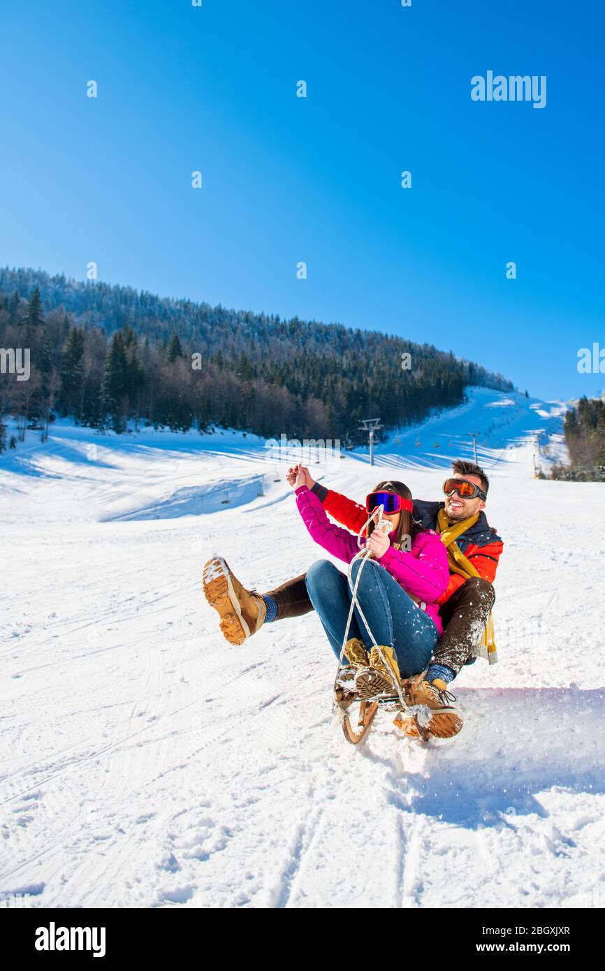 Young Happy Couple On Sledge Having Fun Stock Photo