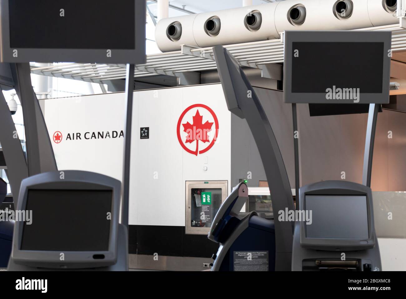 Air Canada logo in-focus through empty, off check-in kiosks during the global COVID-19 pandemic inside Toronto Pearson, Terminal 1. Stock Photo