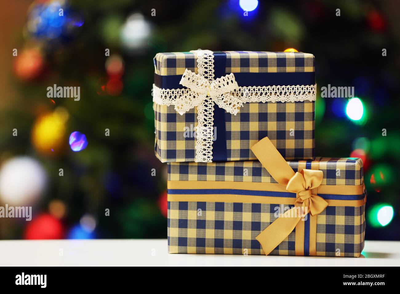 Gift boxes on Christmas tree lights background Stock Photo - Alamy