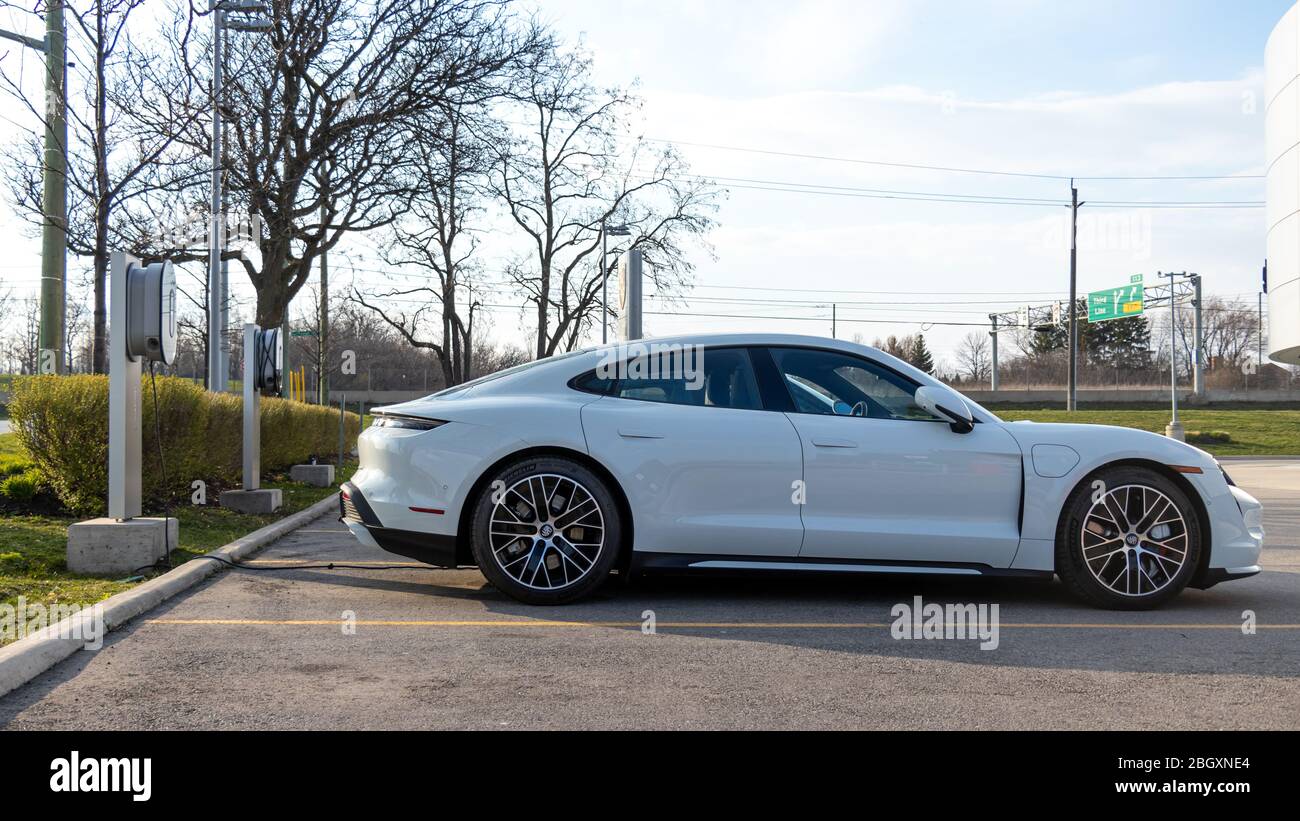 Porsche Taycan Turbo parked at a ￼dedicated EV charging station at a Porsche Dealership. Stock Photo