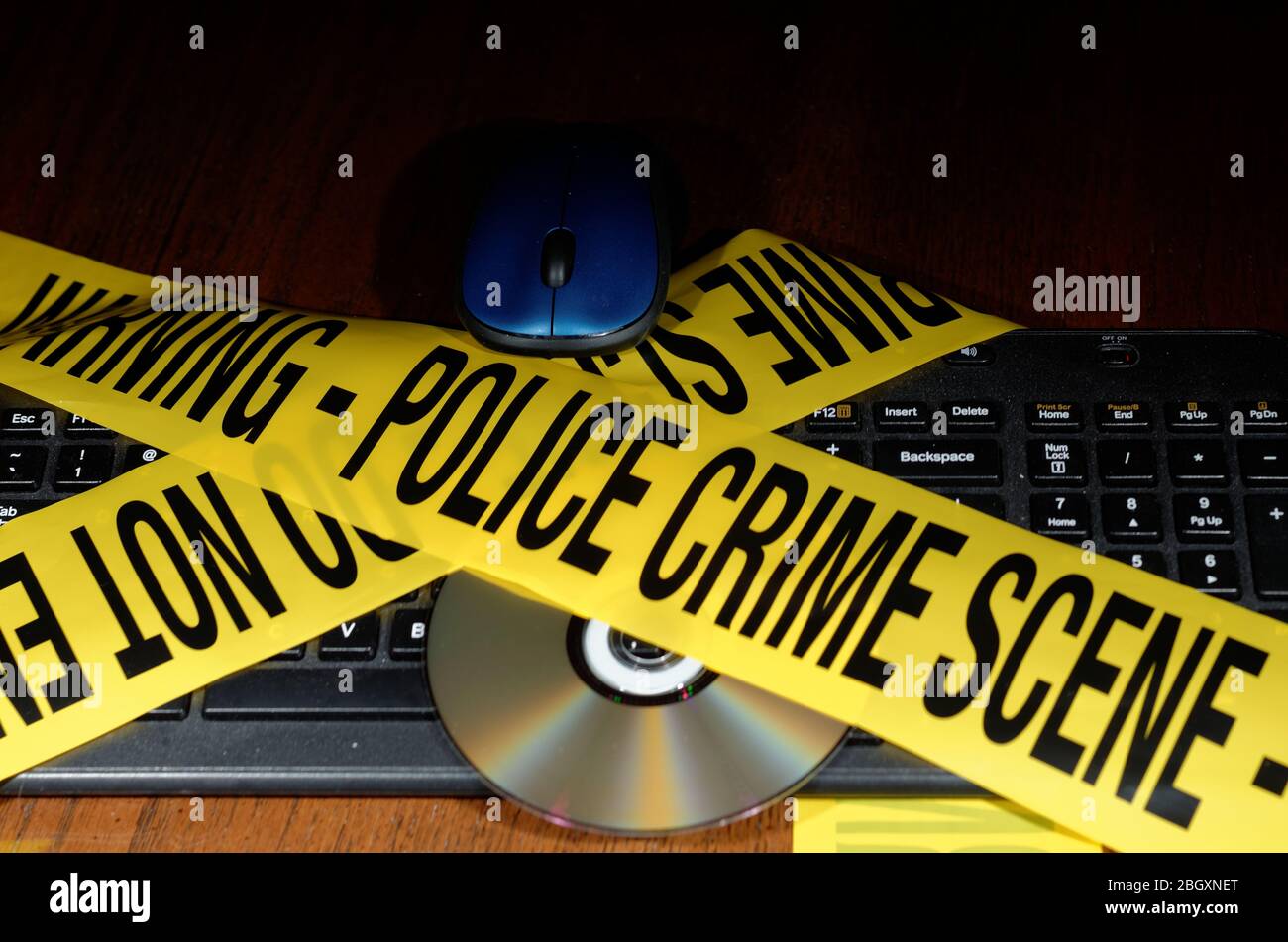 Yellow Police Crime Scene tape across a staged cybercrime scene Stock Photo