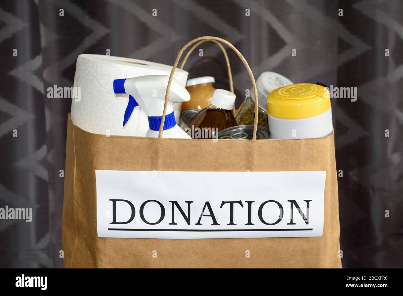 Preparing a donation bag:  food and cleaning supplies are packed and ready to be handed out during the Covid-19 / Coronavirus Pandemic Stock Photo