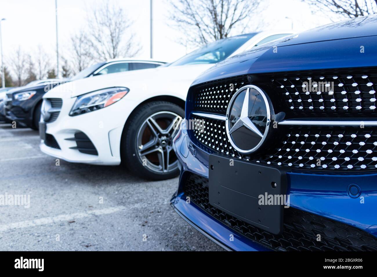 Close-up of the Mercedes-Benz emblem on a new car parked at a dealership. Stock Photo