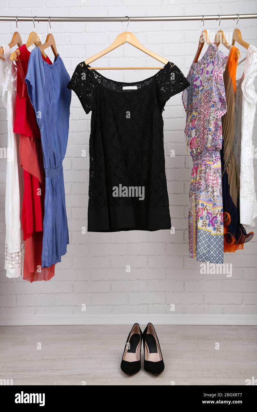 Female dresses on hangers in room Stock Photo - Alamy