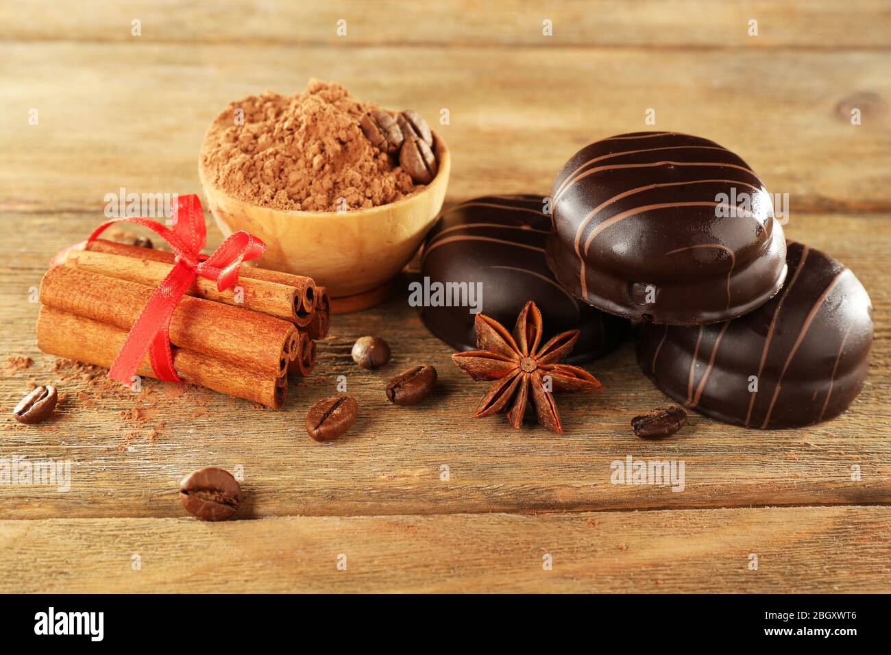 Chocolate cookies with bowl of cocoa and cinnamon on rustic background Stock Photo