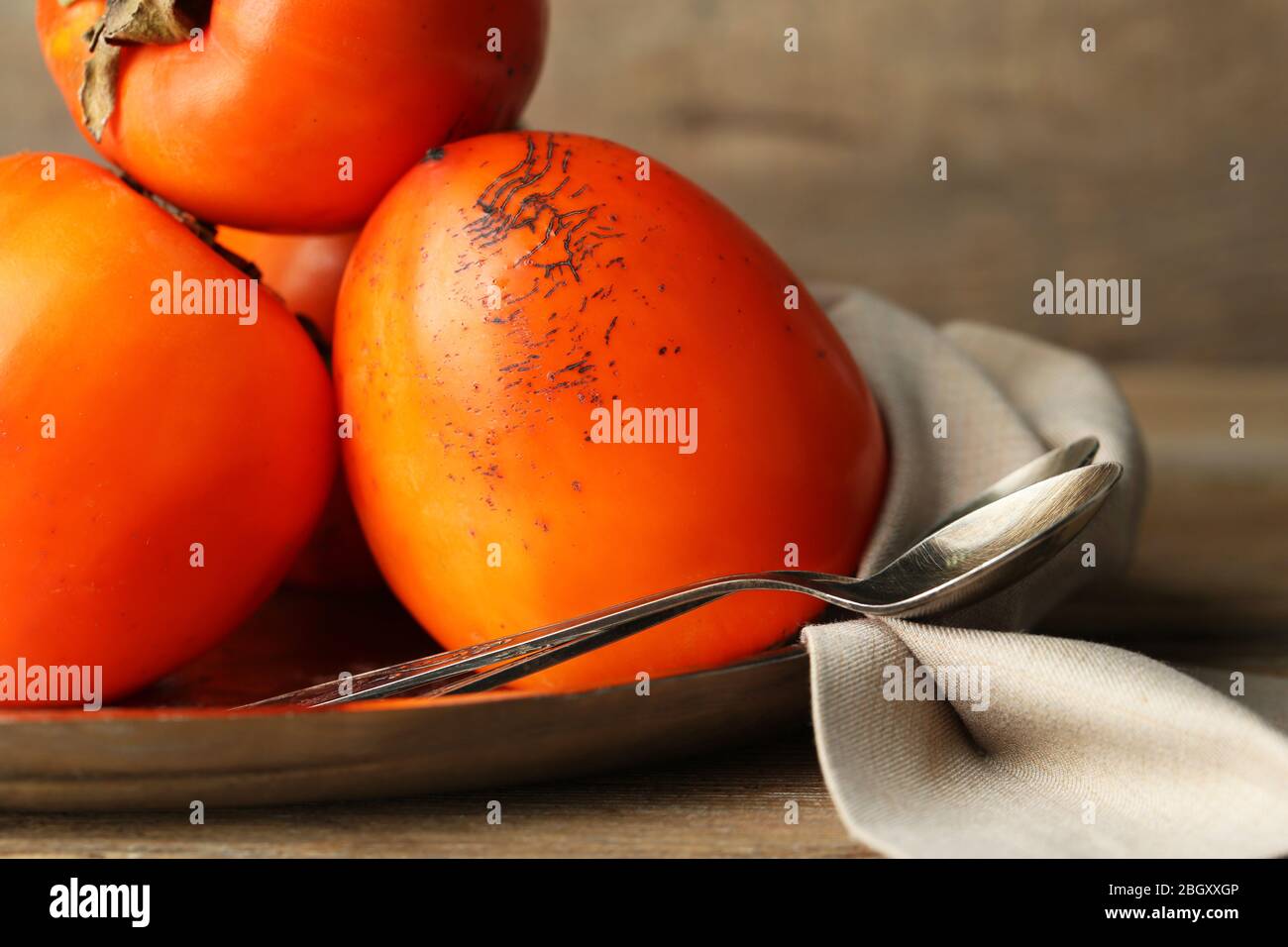 Ripe sweet persimmons, on wooden table Stock Photo - Alamy