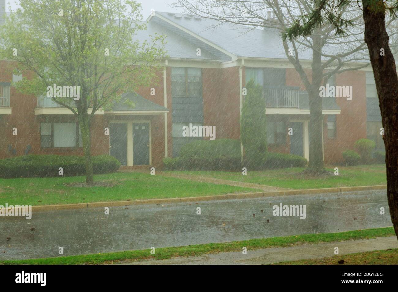 Rain water flowing from apartment building during heavy rainstorm Stock