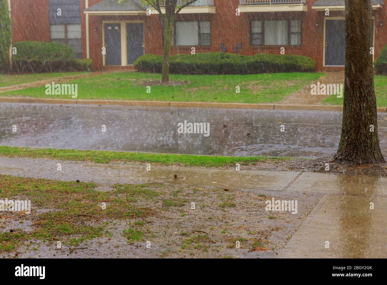 Rainy season on apartment building during strong winds heavy rain drops falling on asphalt Stock