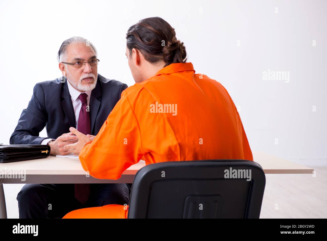 Young captive meeting with advocate in pretrial detention Stock Photo
