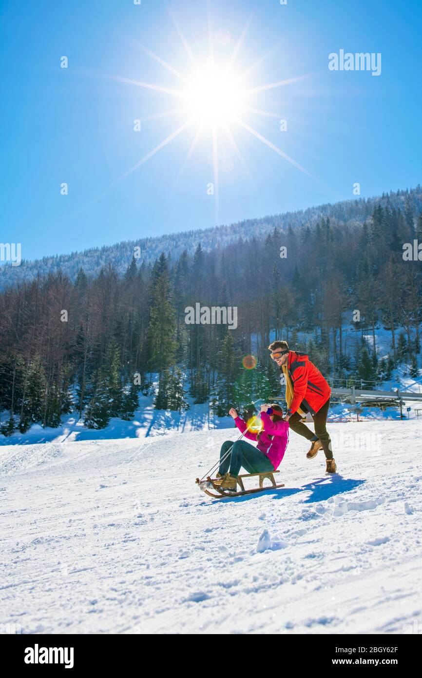 Young Happy Couple On Sledge Having Fun Stock Photo