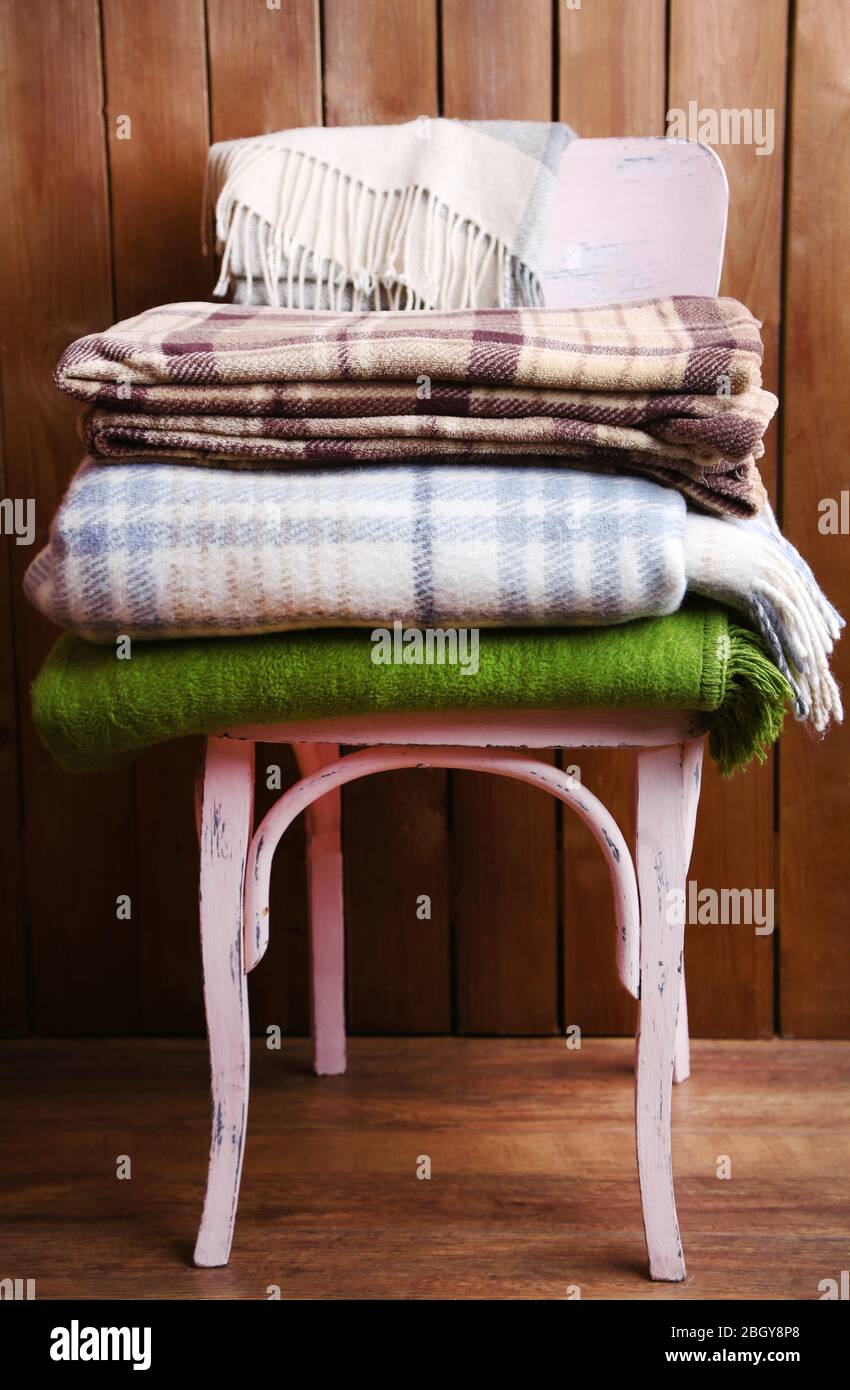 warm plaids on chair on rustic wooden background Stock Photo