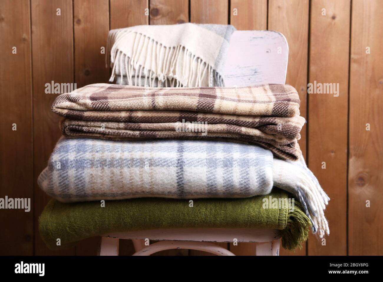 warm plaids on chair on rustic wooden background Stock Photo