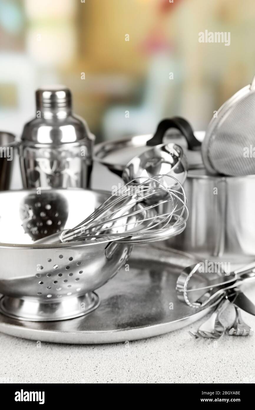 Stainless steel kitchenware on table, on light background Stock Photo ...