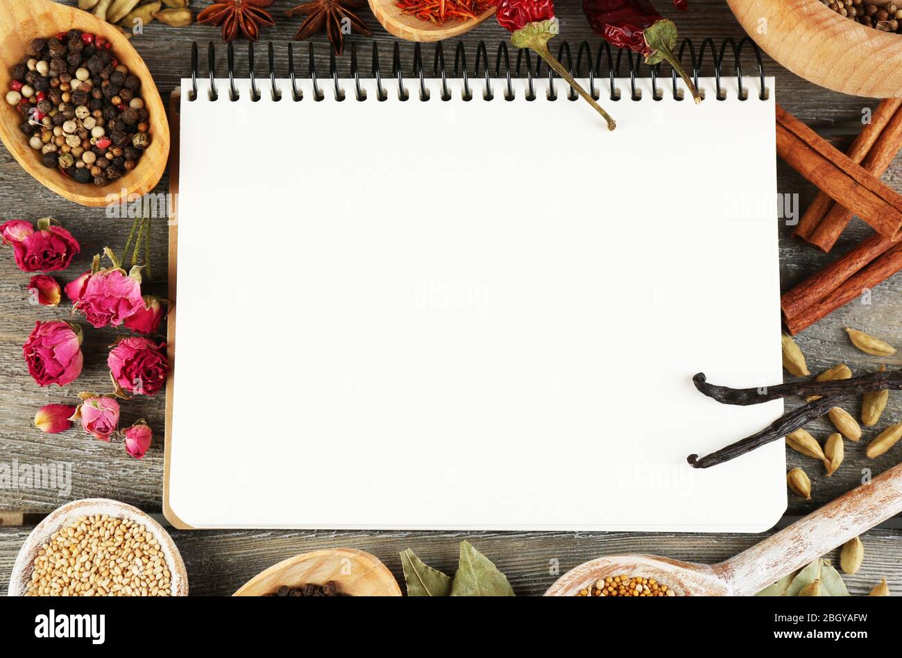 Spices with recipe book on rustic wooden table background Stock Photo