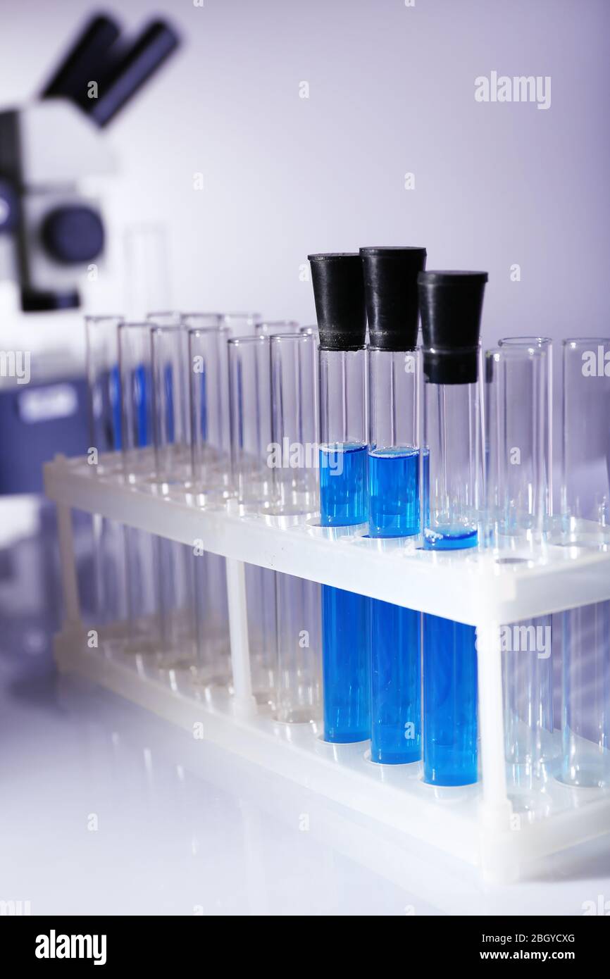 Laboratory glassware with blue liquid on gray background Stock Photo ...