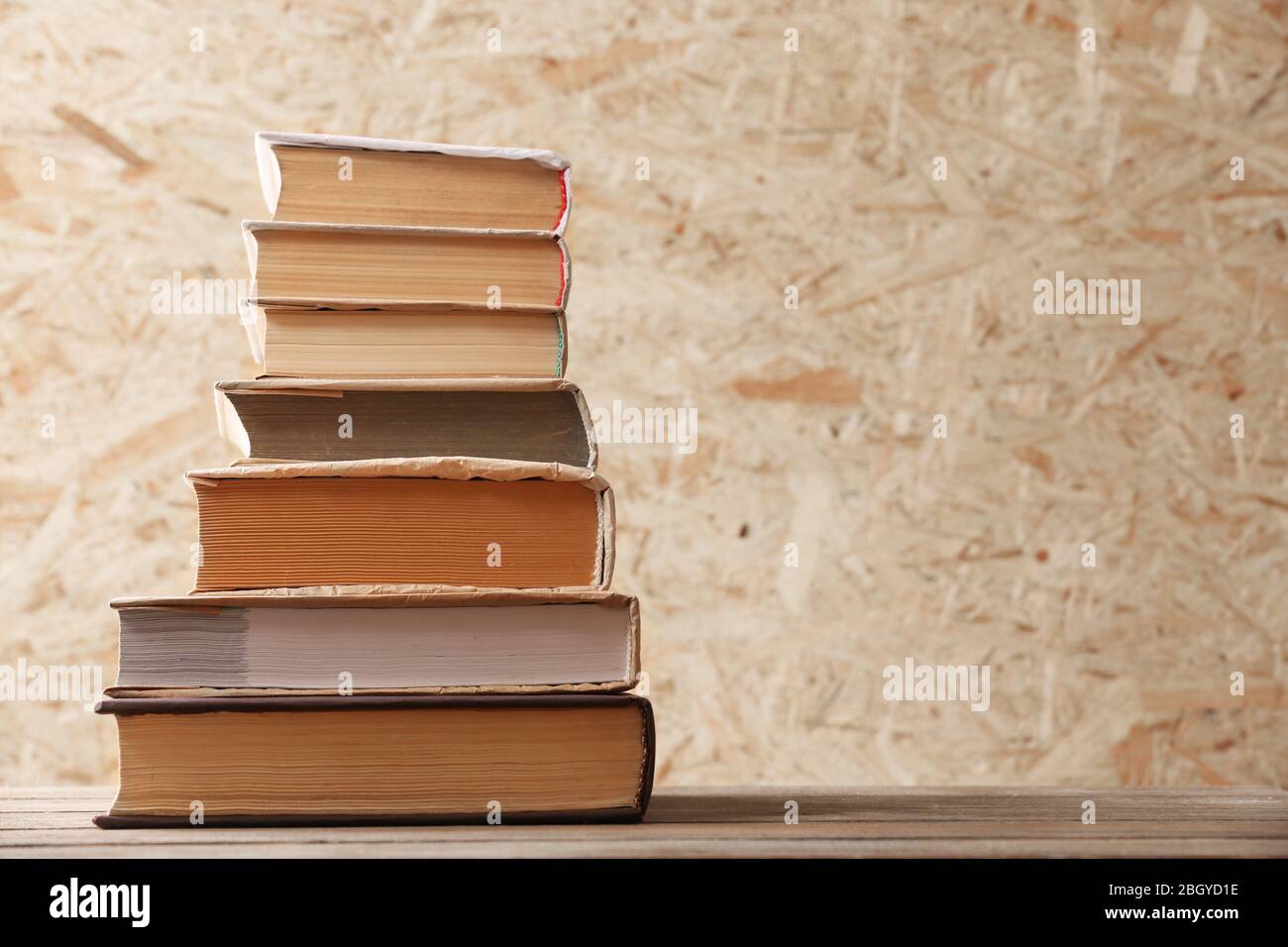Stack of books on wooden hardboard background Stock Photo Alamy