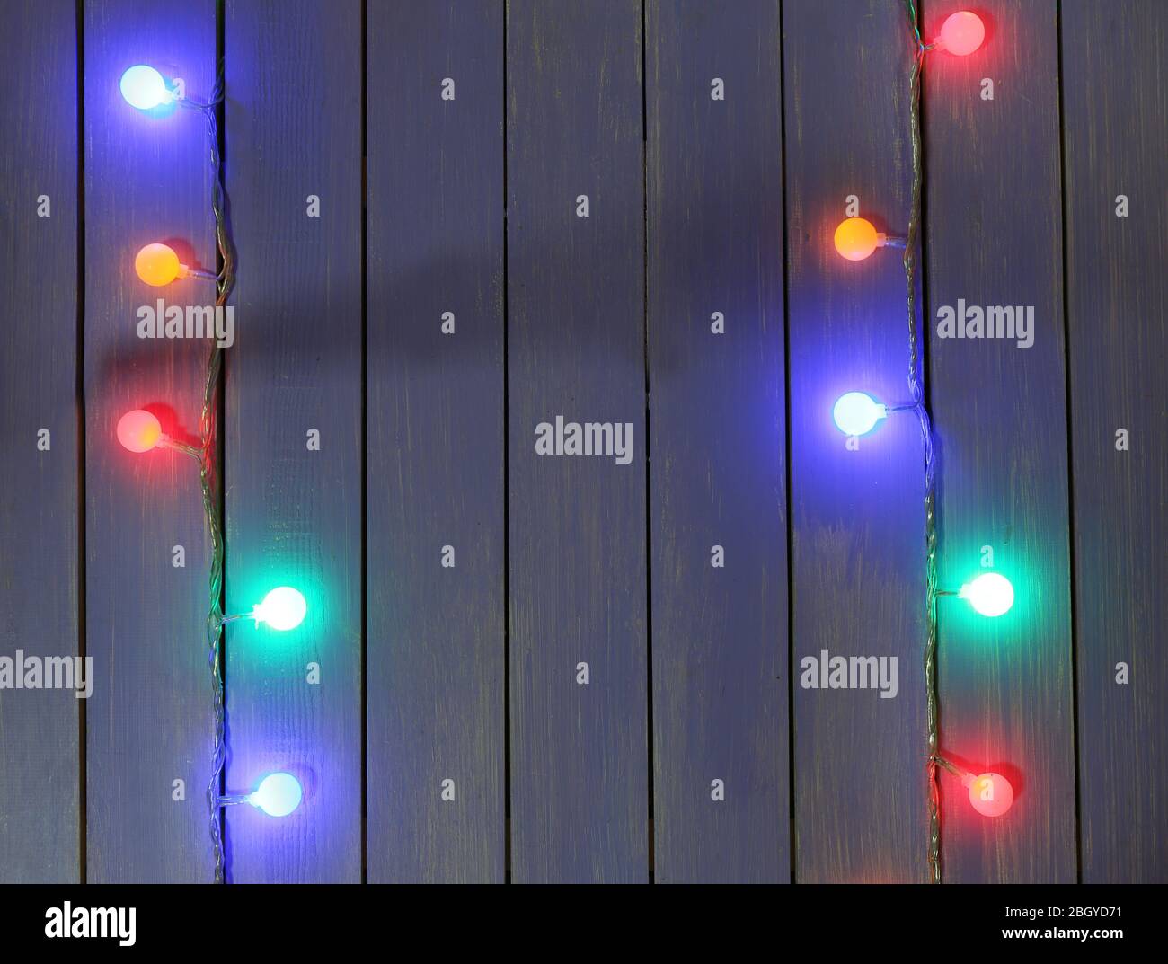 Colorful Christmas lights on wooden planks background Stock Photo - Alamy