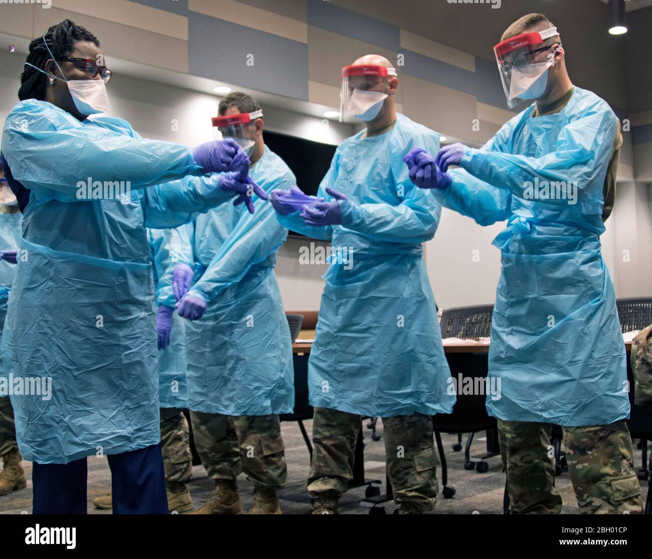 Members of the Florida National Guard (FLNG) gather with local hospital staff to collaborate on donning and doffing personal protective equipment (PPE) during Task Force – Medicals’ response to the COVID-19 virus, March 17, 2020. The FLNG is mobilizing up to 500 Citizen-Soldiers and Airmen in support of the Florida Department of Health response in Broward County. (U.S. Army photo by Sgt. Leia Tascarini) Stock Photo