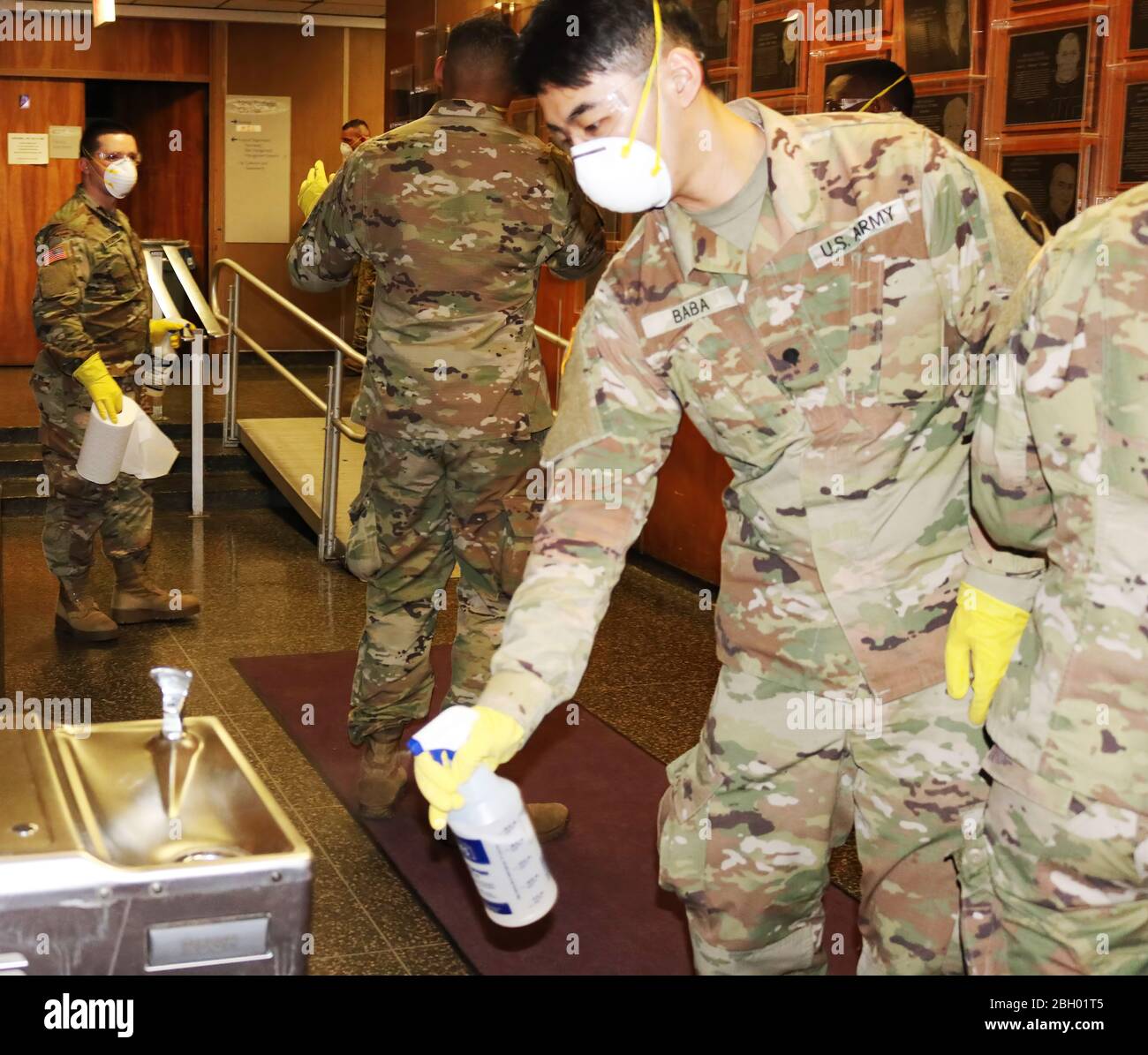 New York Army National Guard Spec. Hideyuki Baba, a member of the 187th Signal Company, sprays a drinking fountain in New Rochelle City Hall on Saturday, March 14 while he and other Soldiers cleaned the building's surface areas as part of the state's efforts to contain the spread of the COVID-19 coronavirus in the city. The National Guard has deployed Soldiers and Airmen to Westchester county to assist state and local officials with efforts to control the virus. Cleaning public spaces is one of the Guard missions. ( Courtesy City of New Rochelle) Stock Photo