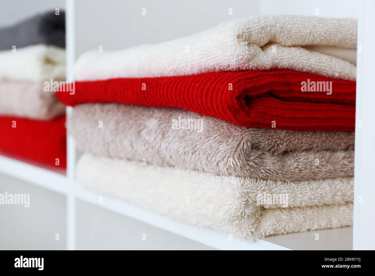 Colorful towels on shelf of rack background Stock Photo - Alamy