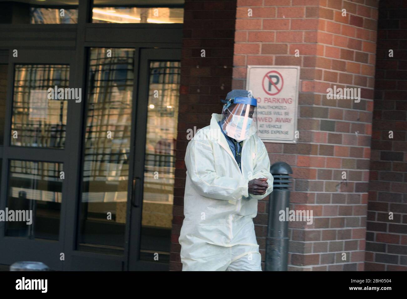 New York, New York, USA. 22nd Apr, 2020. This man dressed in a yellow hazmat, his face covered by a mask and a protective screen, leaves this rehab and nursing center after disinfecting his hands in the Bronx, New York City. 3425 residents of New York state nursing homes including 554 in Bronx have died so far because of COVID-19. That represents nearly 25% of the state's pandemic deaths. Credit: Marie Le Ble/ZUMA Wire/Alamy Live News Stock Photo