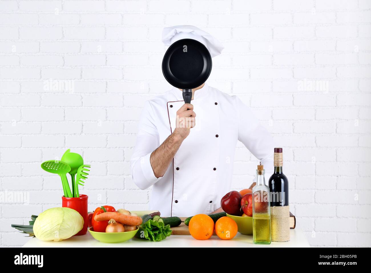 Chef at table with different products and utensil in kitchen on white ...