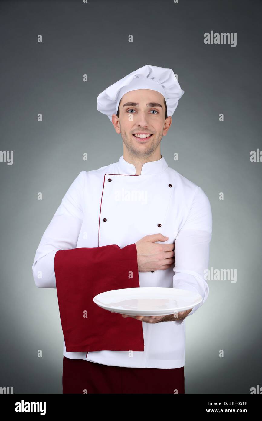 Chef with towel on hand and plate on dark background Stock Photo - Alamy