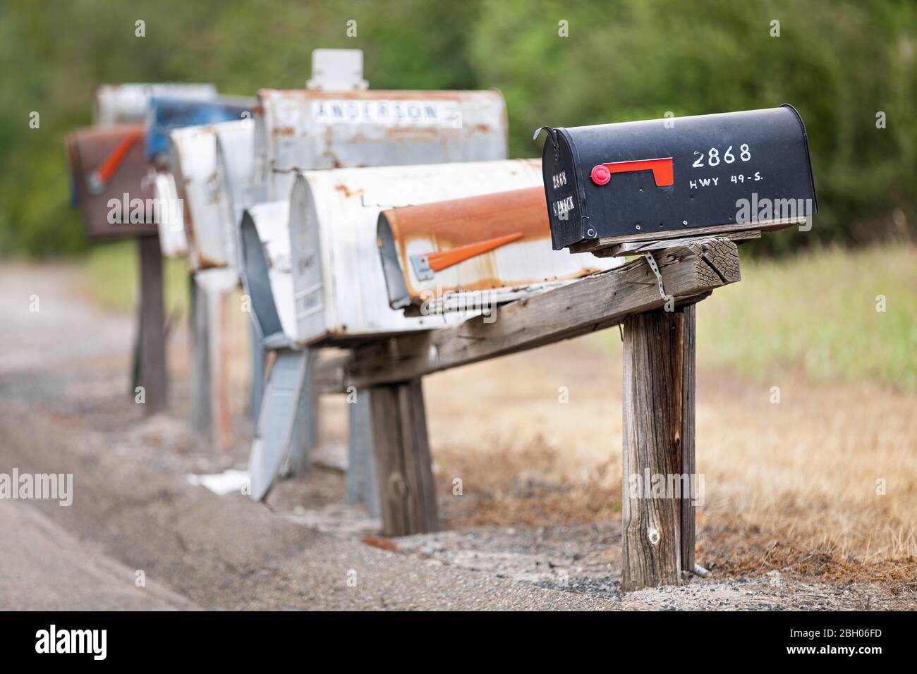 Close up of a long row of old and rusty american curbside letterboxes Stock Photo