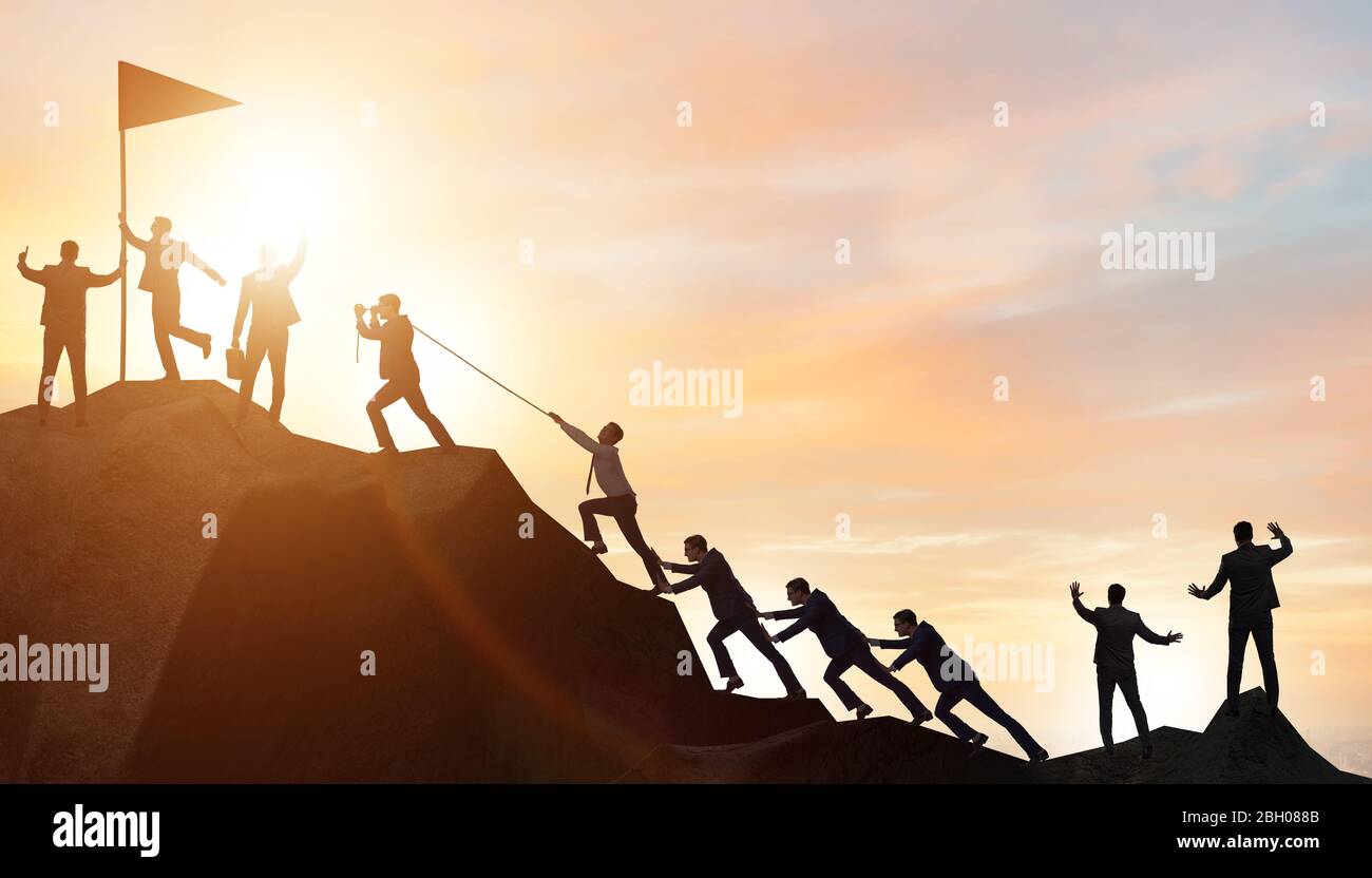 Concept of teamwork with team climbing mountain Stock Photo