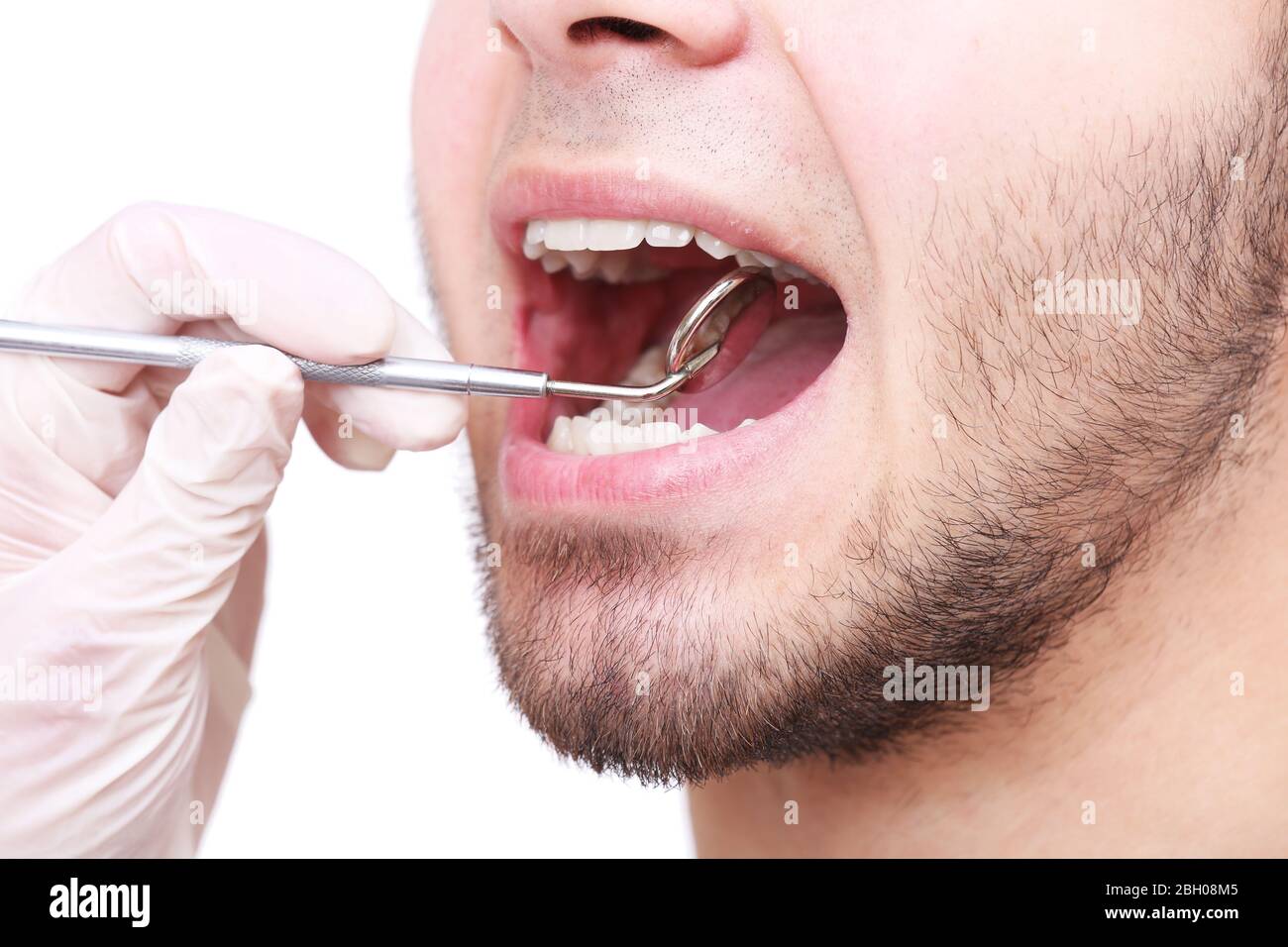 Examine of young man by dentist isolated on white background Stock Photo