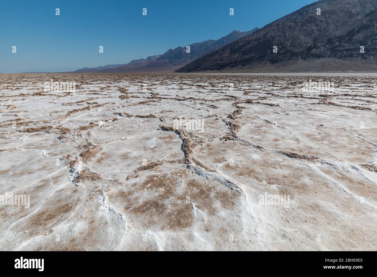 Low angle shot of the salt lake in Badwater Basin, Death Valley, with mountains in the distance Stock Photo