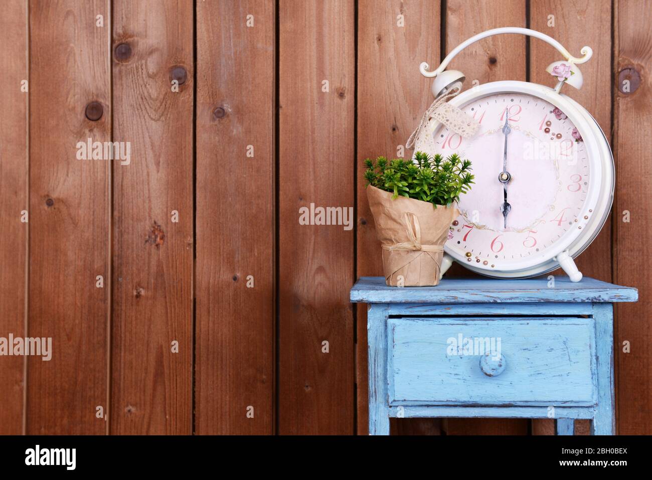 Interior design with big alarm clock and plant on tabletop on wooden ...