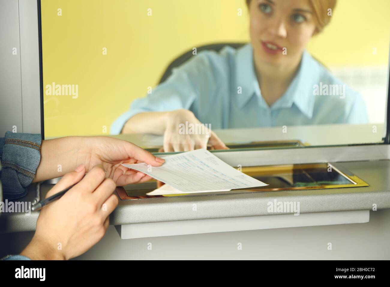 Teller window with working cashier Stock Photo Alamy