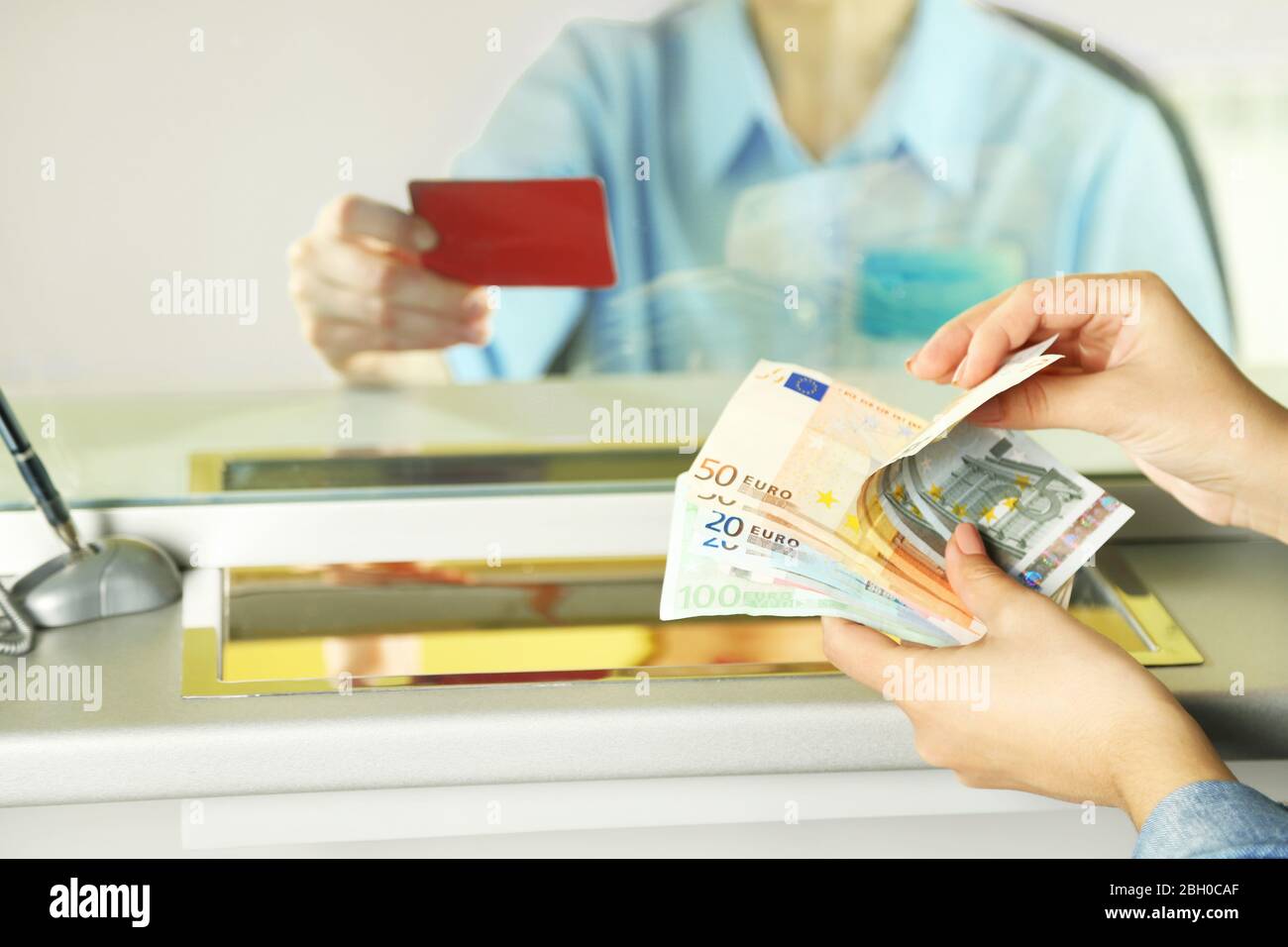 Teller window with working cashier Stock Photo