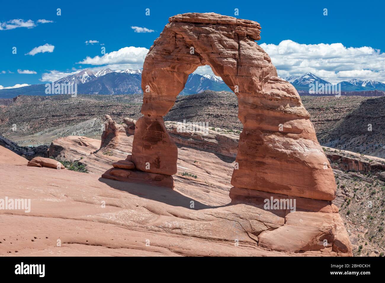 The famous Delicate Arch, Utah, in a sunny day against snow-capped mountains Stock Photo