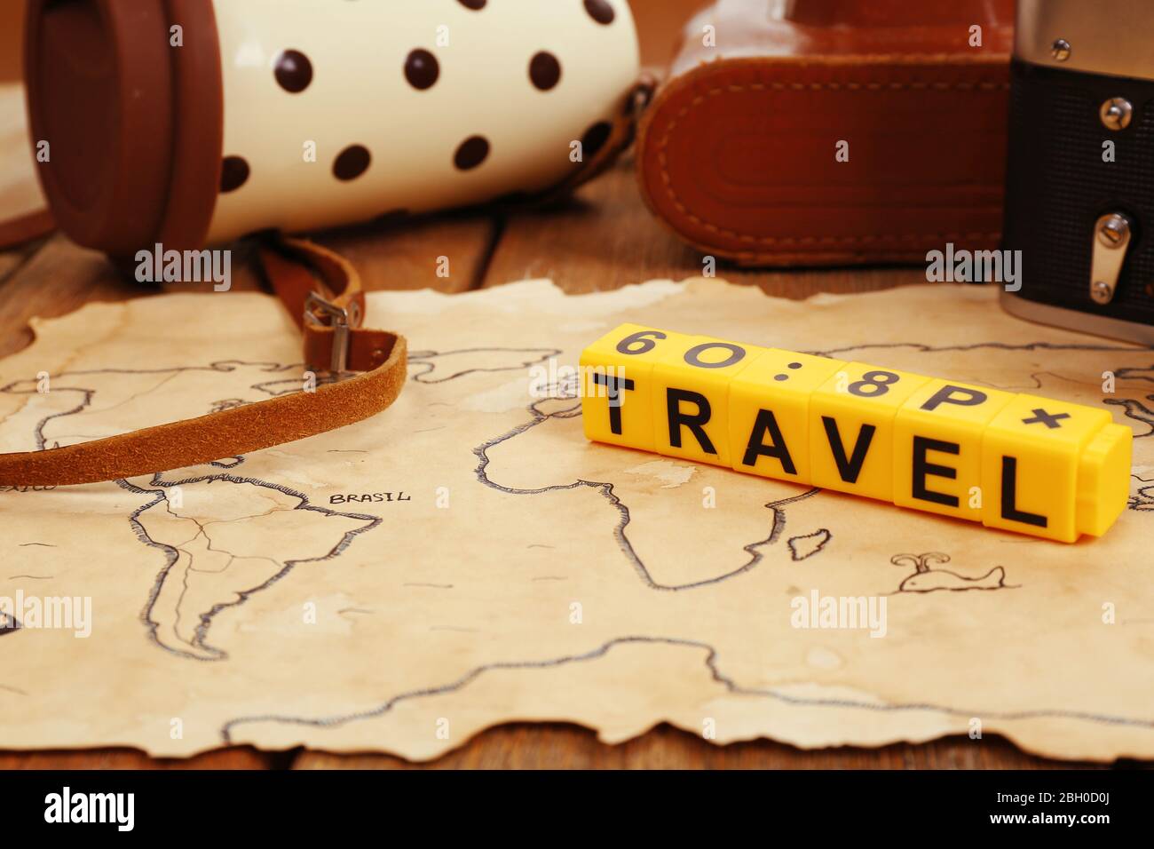 Retro camera on world map with word Travel on wooden table background Stock Photo