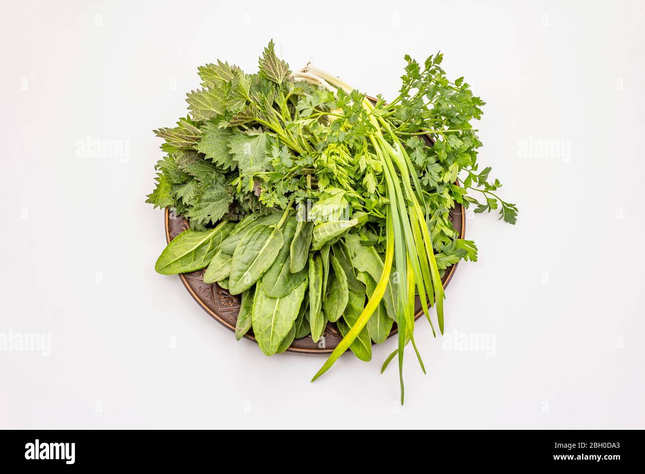 Fresh greens set isolated on white background. Nettle, sorrel, parsley, garlic. Traditional ingredients for spring soup Stock Photo