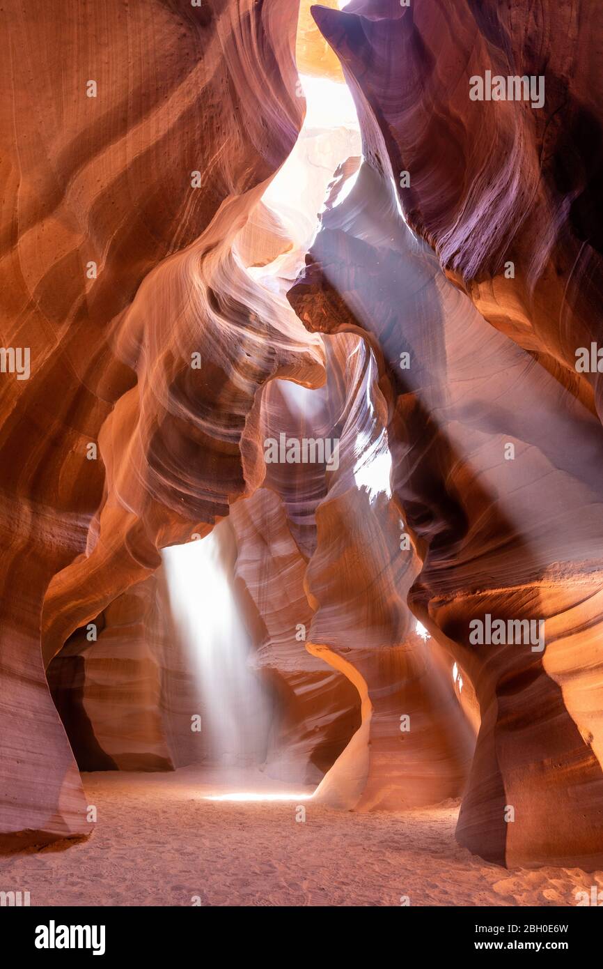 Interior of the Upper Antelope Canyon with three sunbeams filtering between the rocks Stock Photo