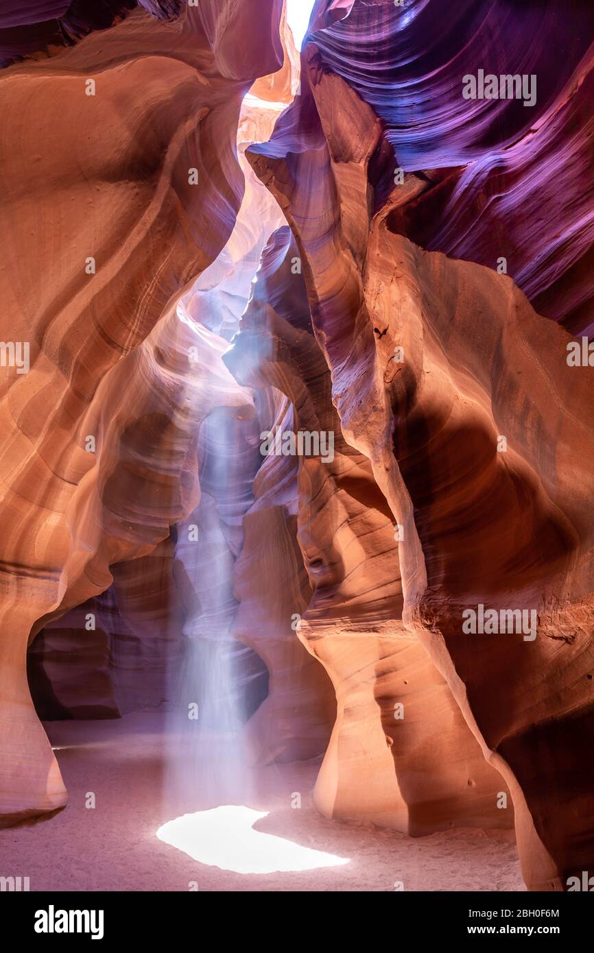 In the Antelope Canyon, a ray of sun light shines from an opening in the vault Stock Photo