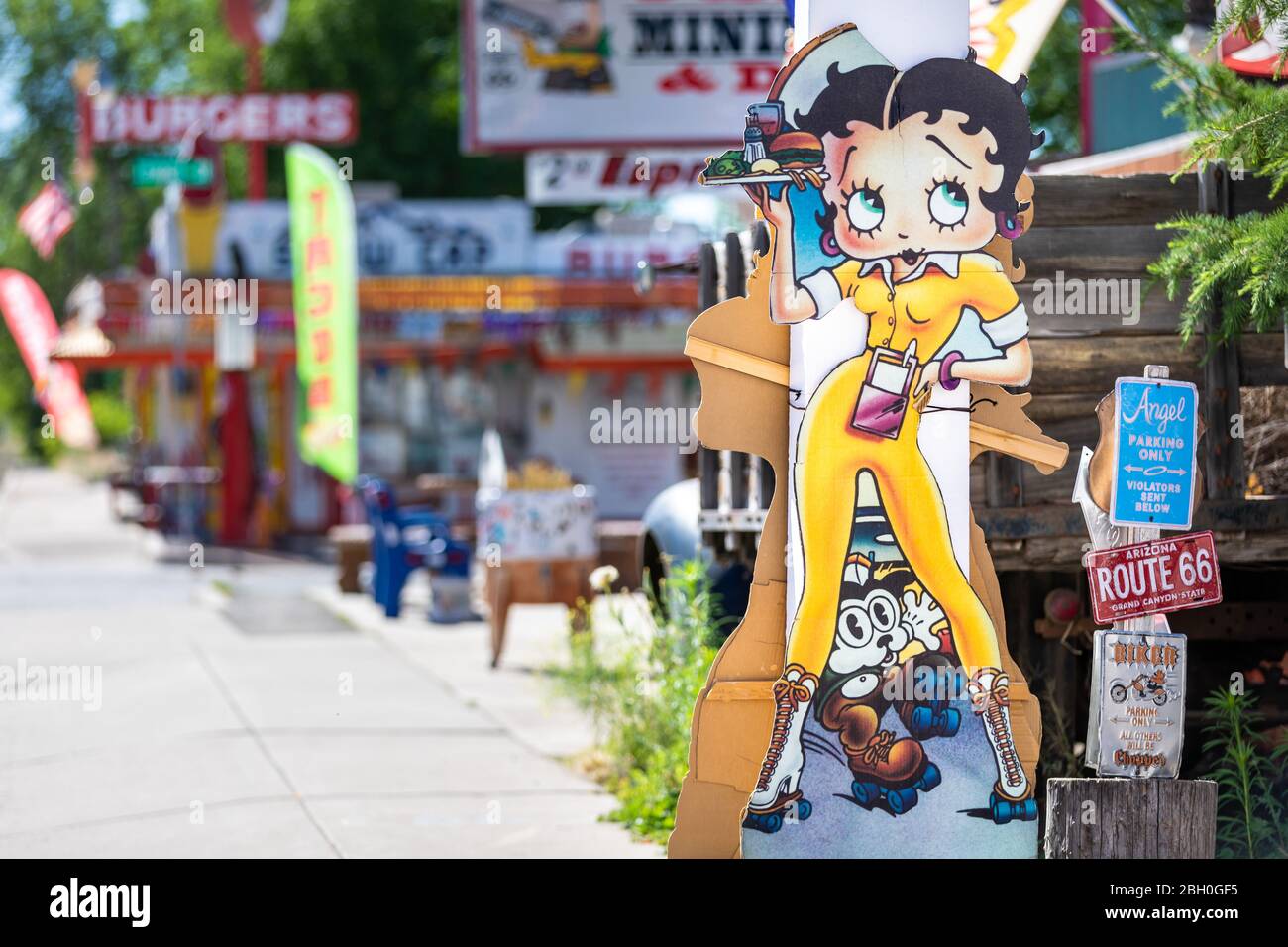 Close up of a row of roadside shops with colorful signs, and a cutout of Betty Boop in the foreground Stock Photo