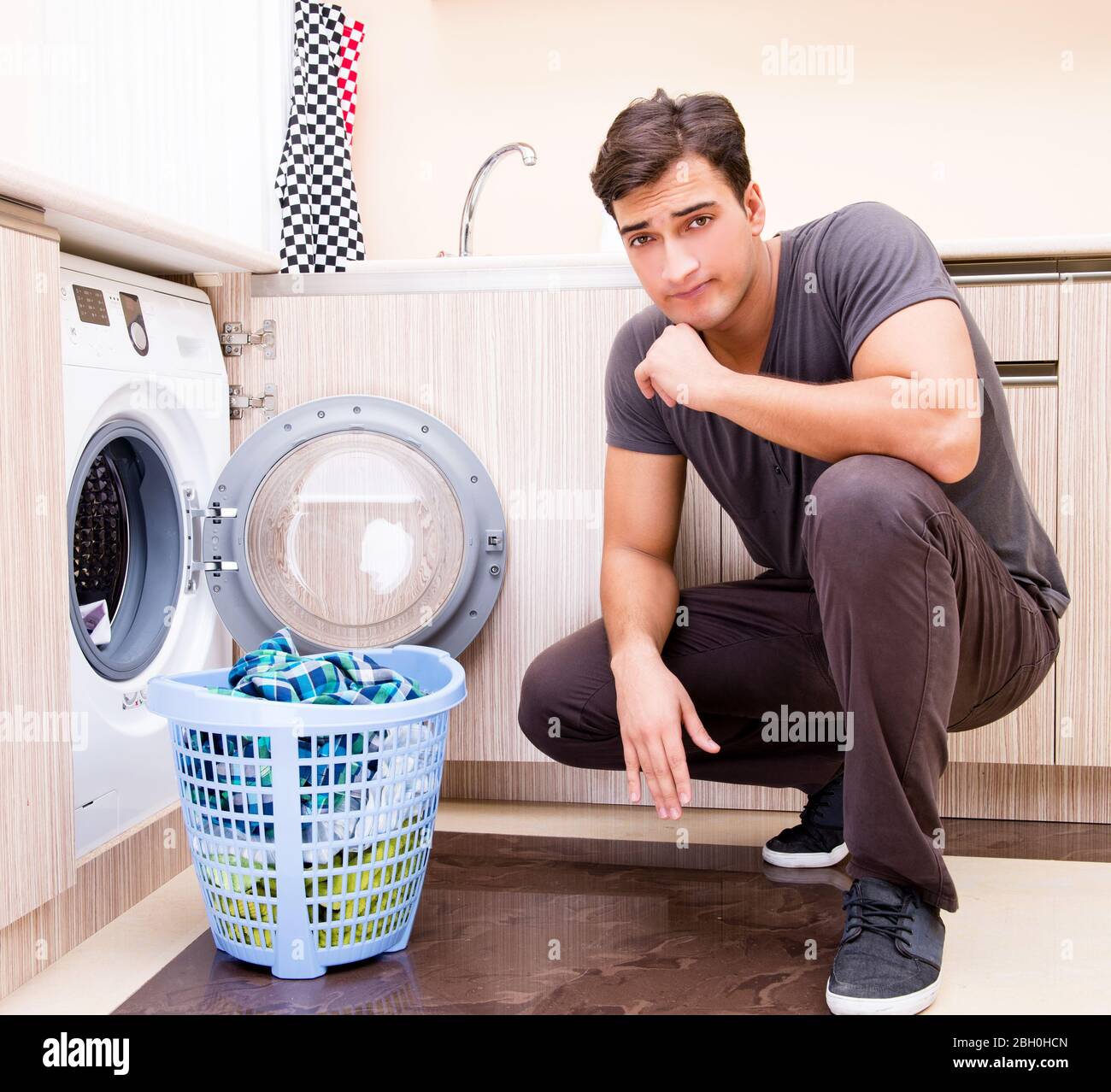 The young husband man doing laundry at home Stock Photo - Alamy