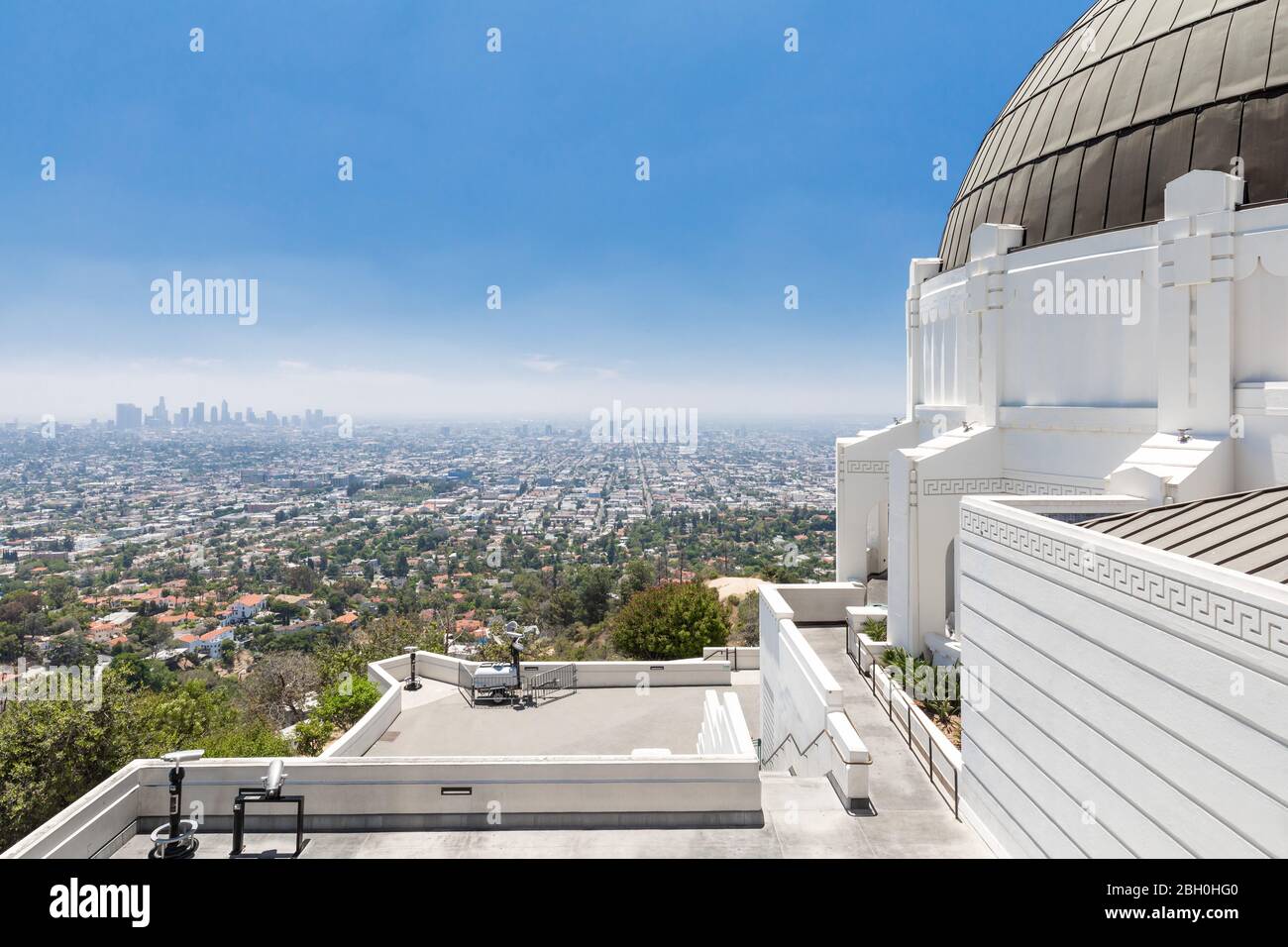 Wide angle view of the Griffith Observatory overlooking the city of Los Angeles, under a blue summer sky Stock Photo