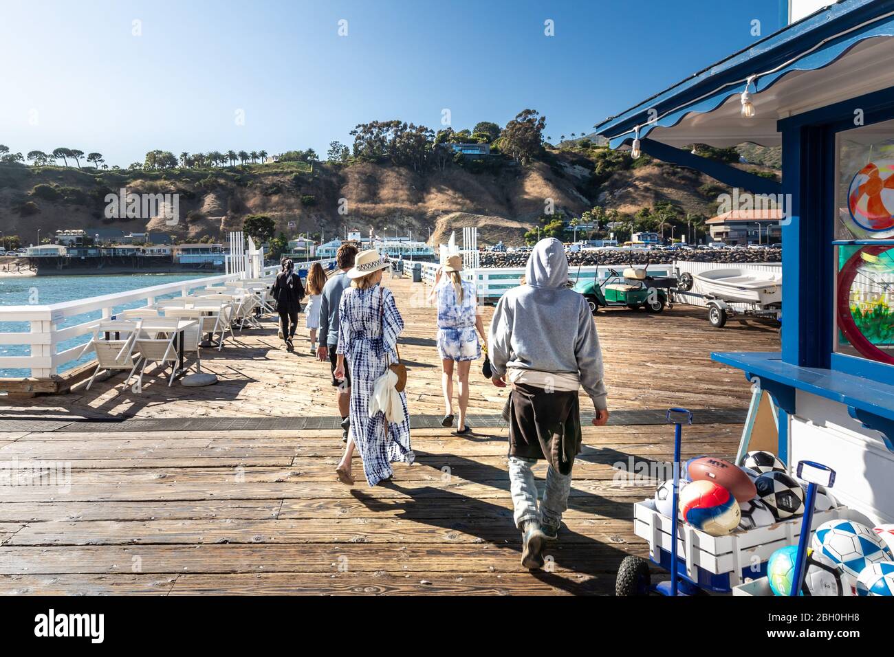Iconic view of Malibu as seen from the pier, in a sunny summer day, with a group of people walking away in the late afternoon light Stock Photo