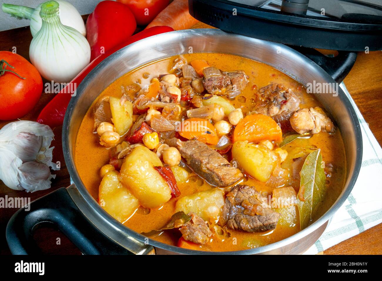 Beef stew in a large pot with vegetables and a wood table, seen from directly above ,part of a series Stock Photo