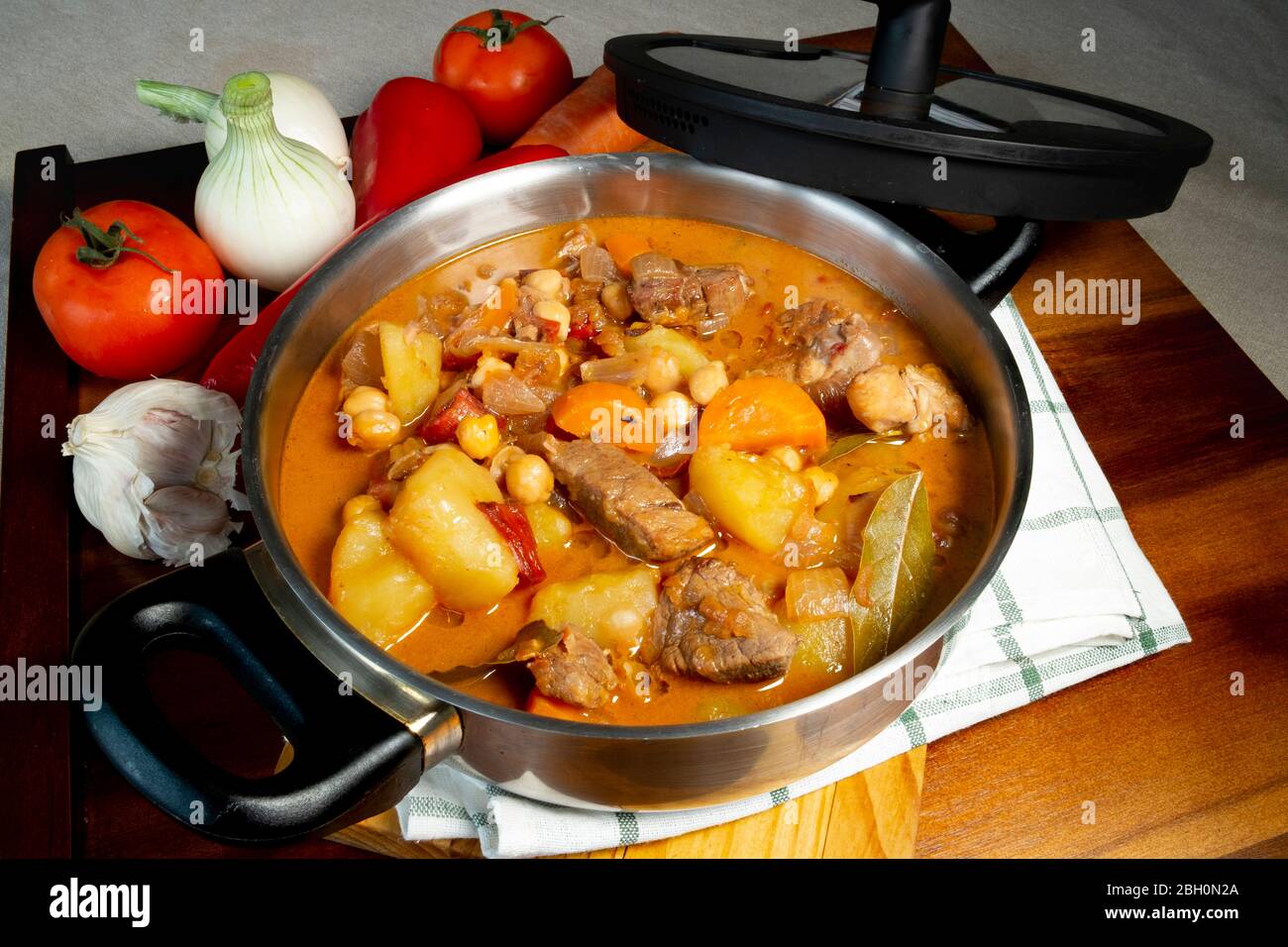 Beef stew in a large pot with vegetables and a wood table, seen from directly above ,part of a series Stock Photo